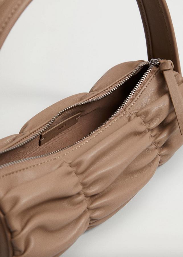 Diseño baguette para este bolso en marrón pastel, de tamaño pequeño, asa corta y detalles fruncidos. Con cierre de cremallera superior, tiene un precio de 19,99 euros.