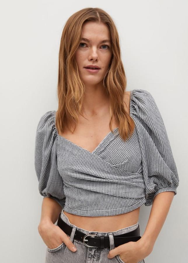 El estampado vichy más pequeño que hemos visto en el low cost lo encontramos en este top de Mango. Nos encanta el patrón, con un escote cruzado súper favorecedor y esas mangas abullonadas francesas (19,99 euros).