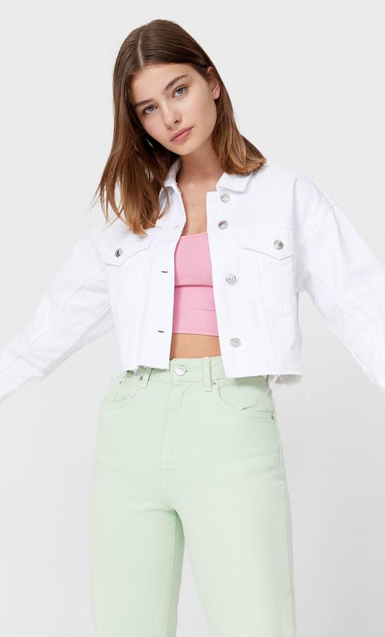 En tejido denim de color blanco, esta cazadora corta con puños abotonados y bolsillos en el pecho tiene un precio de 25,99 euros.