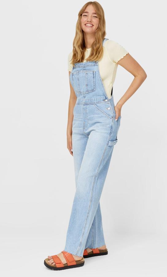 En color azul claro, este peto denim con escote recto y tirantes anchos ajustables cuenta con botones metálicos en los laterales y pernera ancha. Tiene un precio de 35,99 euros.
