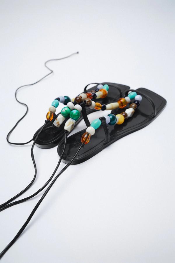 En color negro con abalorios multicolor en el corte, esas sandalias acabadas en punta cuadrada y con cierre mediante tira atada al tobillo son de Zara y tienen un precio de 29,95 euros.