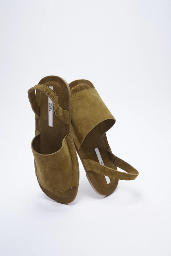 Disponibles en verde caqui o en marrón, estas sandalias planas de piel con tira en la parte trasera son de Zara y tienen un precio de 25,95 euros.