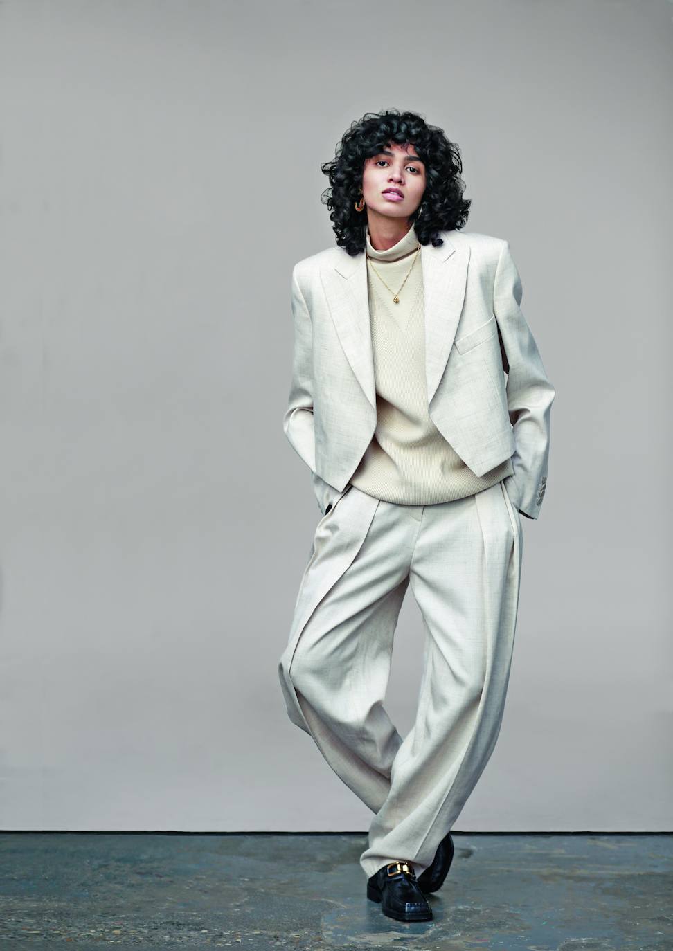 Americana, jersey de cuello alto y pantalones, todo de Stella McCartney. El colgante y los mocasines son de Uterqüe.