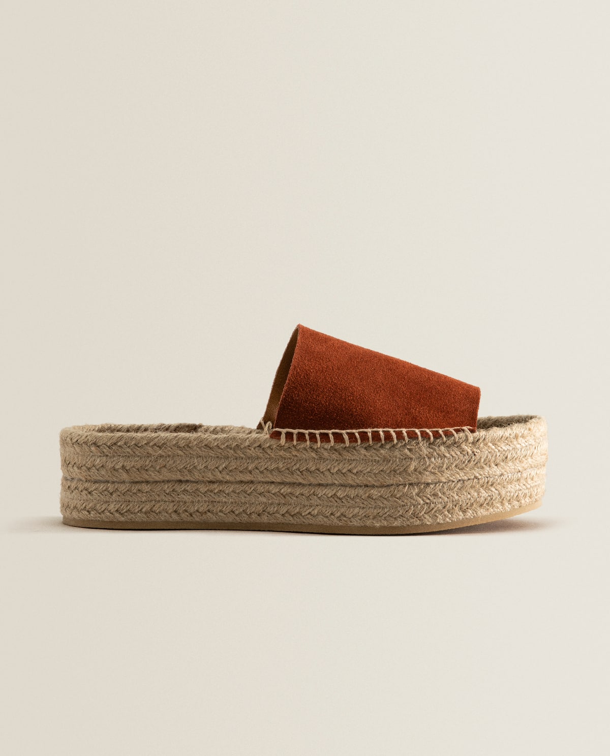 Sandalias de piel en color teja con plataforma de esparto. Un imprescindible del verano que estiliza la figura al máximo. (25,99 euros).