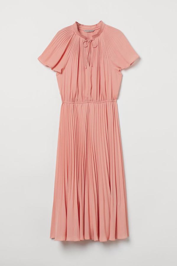 Este vestido suavemente plisado tiene un patrón tan clásico, que lo recomendamos especialmente para veinteañeras con ganas de dar un golpe de efecto lady, y para romper con un color inesperado más allá de los 50. Es un vestido súper favorecedor confeccionado en crepé, con mangas ranglán cortas, cuello elevado con lazada fina y costura elástica fina en la cintura (H&M, 39,99 euros).