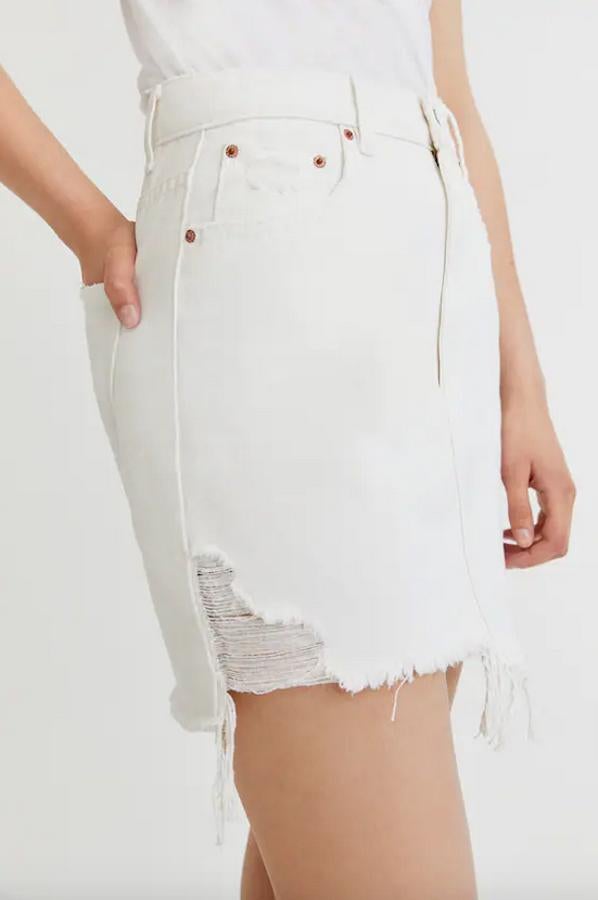 Con rotos en el bajo, cierre de cremallera y botón y cinco bolsillos, esta minifalda blanca de Pull&Bear tiene un precio de 19,99 euros y podemos encontrarla entre las tallas XS y XL.