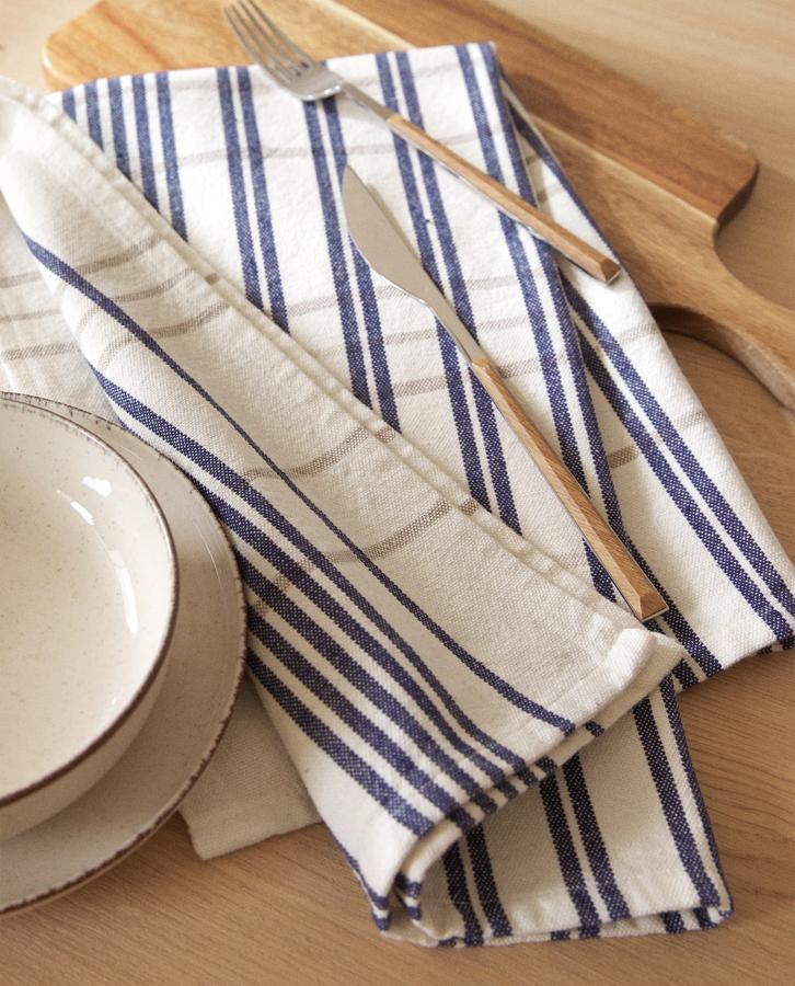 Juego de dos paños de cocina con estampado de rayas en color beis y azul disponibles por 7,99 euros.