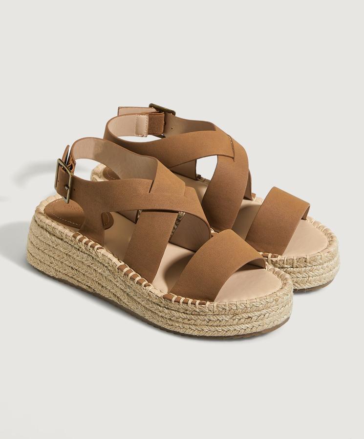 Estos zapatos de cuña forrada en yute con corte en color marrón tienen cierre mediante hebilla y un precio de 27,99 euros.