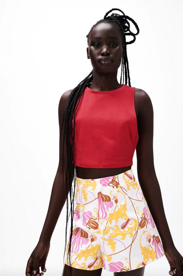 Diseño cropped para esta camiseta de cuello redondo con cuello halter y mangas sisa, disponible en cinco colores entre ellas el fucsia, el naranja o el visón medio. Confeccionada con al menos un 50% de algodón orgánico, podemos encontrarla entre las tallas S y XL por 5,95 euros.