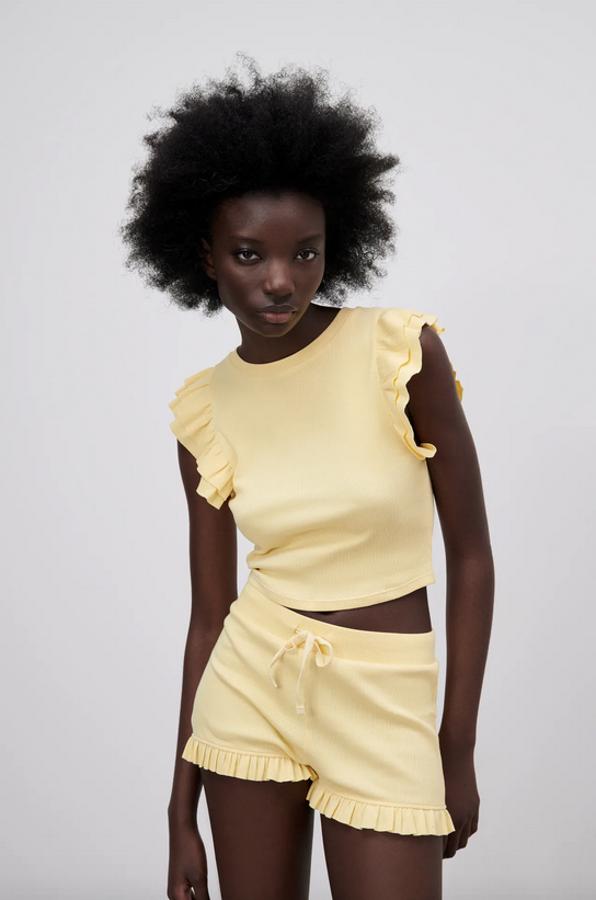 Con manga sisa acabada en volantes, esta camiseta corta de cuello redondo disponible en negro, blanco y amarillo cuesta 7,95 euros y está disponible en las tallas S, M y L.