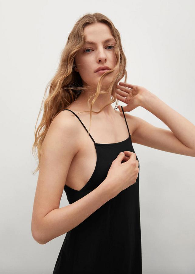En tejido elástico, con diseño midi acampanado, este vestido negro de escote recto, sin mangas y con tirantes finos en los hombros y en la espalda, que queda al aire, estará disponible entre las tallas XS y XL por 25,99 euros.