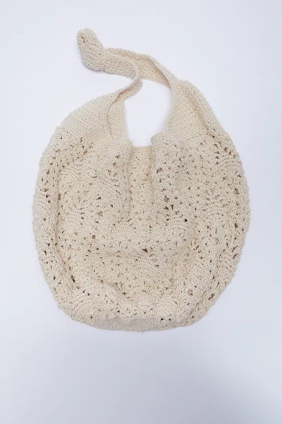 Bolso maxi de crochet trenzado en color crudo. Ideal para guardar todo lo que necesites y más. (35,95 euros).