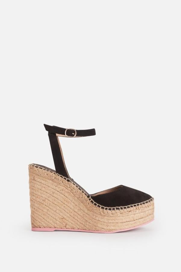 Cuña cerrada en la parte delantera con cierre en el tobillo. Tiene las tiras de ante en tono negro y es de esparto natural (109 euros).