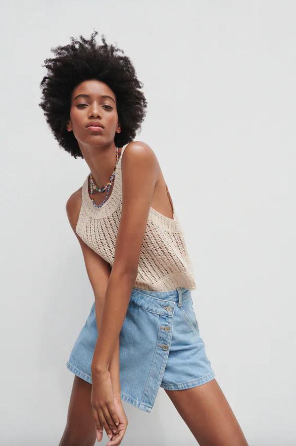 De tiro alto, con cinco bolsillos y en efecto lavado, esta falda pantalón denim con cierre de botones lateral es de Zara, cuesta 19,95 euros y podemos encontrarla entre las tallas XS y L.