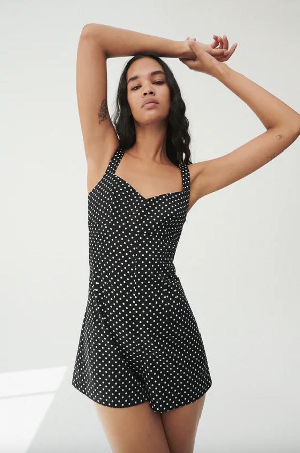 En color negro con lunares blancos, este mono corto de escote de corazón y tirantes medios tiene un precio de 29,95 euros y está disponible entre las tallas XS y XXL.
