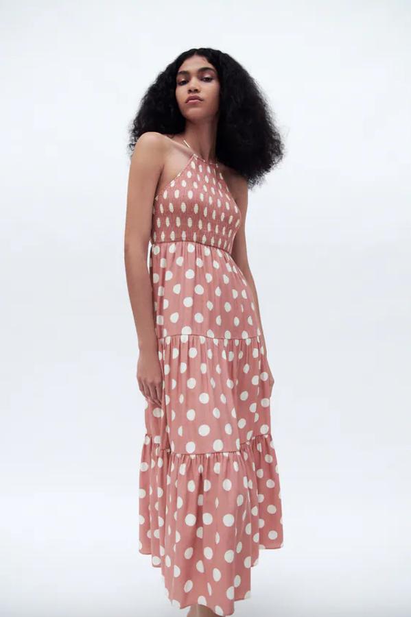 Con cuello halter con tirantes cruzados en la espalda y cuerpo en tejido elástico tipo nido de abeja, este vestido rosa con estampado de lunares blancos está confeccionado con al menos un 50% de lino sostenible y tiene un precio de 39,95 euros. Podemos encontrarlo entre las tallas XS y L.