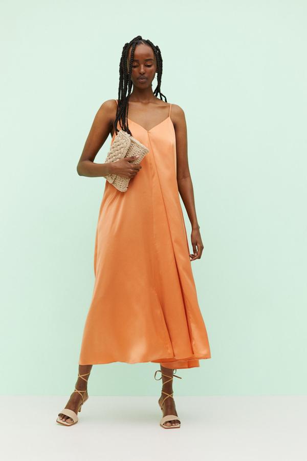 Este vestido de satén color melocotón con silueta fluida, además de muy favorecedor, es cómodo y muy fresquito, perfecto para las celebraciones de verano. Cuesta 29.99 euros en H&M.