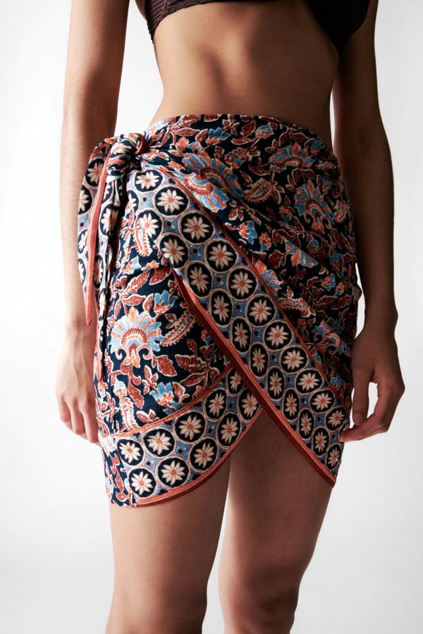 Con estampado multicolor, esta falda pareo corta de tiro alto y bajo asimétrico es de Zara y tiene un precio de 25,95 euros.