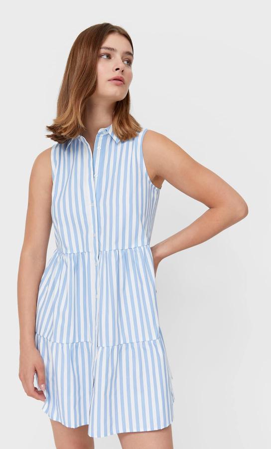 Es vestido camisero corto con estampado de rayas en color azul cuenta con cierre delantero con botones y tiene un precio de 15,99 euros.