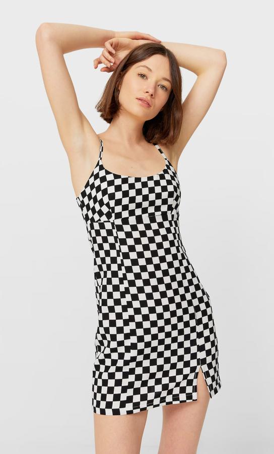 Con estampado de cuadros en blanco y negro, este vestido corto con escote recto y tirante fino tiene un precio de 19,99 euros.