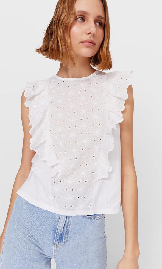De cuello redondo, con detalle de volantes en el cuerpo y sin mangas, este top de Stradivarius con motivos de bordado suizo está disponible en las tallas S, M y L por 15,99 euros.