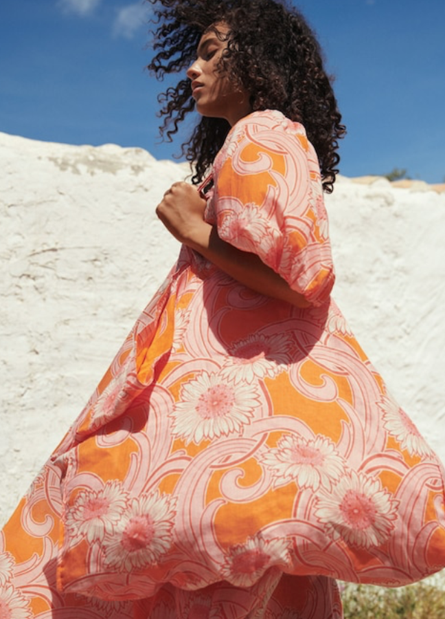 Bolso gigante confeccionado en lino y con dos asas cortas, lleva el estampado de margaritas rosas sobre fondo naranja más llamativo de la selección, Lleva un bolsillo interior y cierra con un imán (49,99 euros).