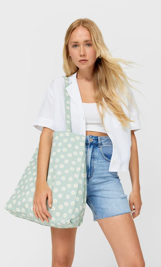 En verde azulado con estampado de margaritas y dos asas largas, este bolso shopper de Stradivarius de diseño vertical cuesta 9,99 euros.