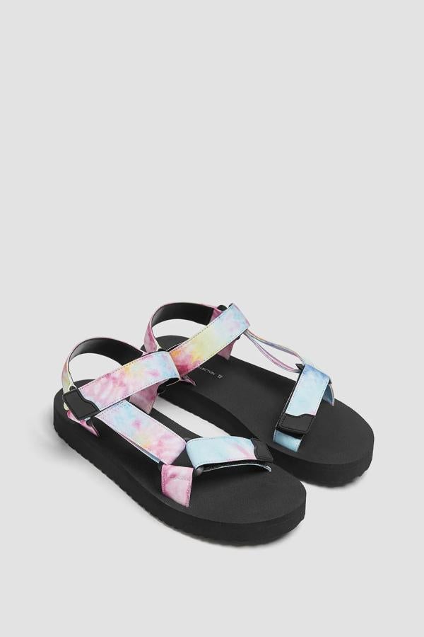 Con detalle de tiras con estampado tie dye, esta sandalia plana con una altura de suela de 2,5 centímetros cuenta con cierre mediante tiras adherentes y tiene un precio de 19,99 euros.
