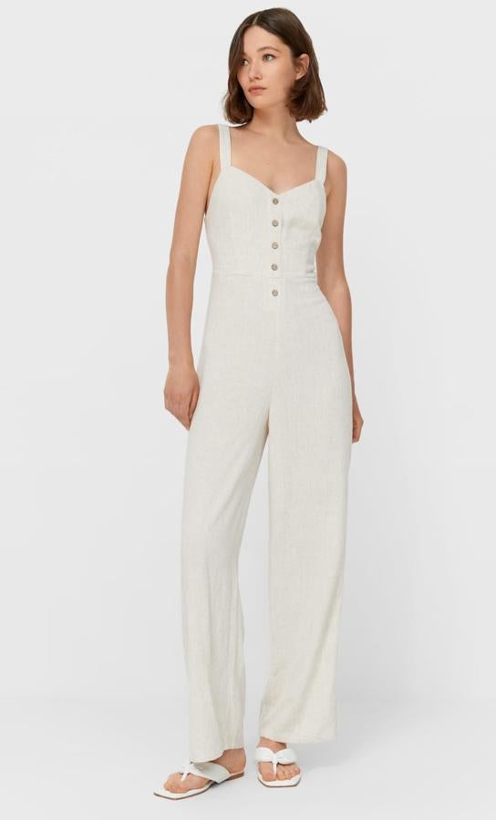 Este mono largo con escote recto y tirantes finos cuenta con pernera amplia y detalle de botones en el escote. EN color piedra, tiene un precio de 25,99 euros.