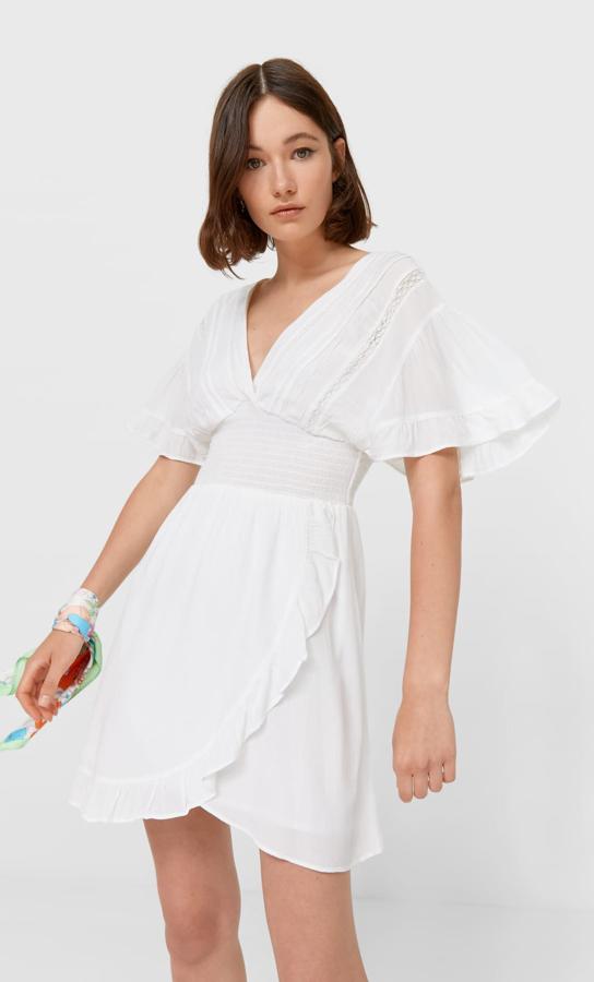 En color crudo, este vestido corto con escote de pico y manga corta con volante cuenta con detalle de comas en la cintura y tiene un precio de 29,99 euros.