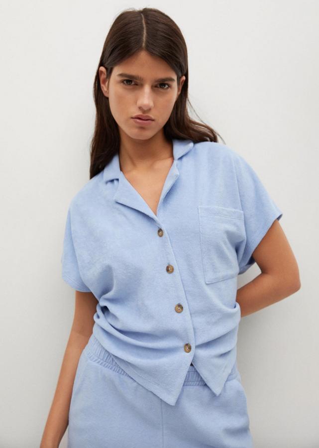 En azul celeste, confeccionado en tejido de algodón con diseño toalla, este polo es de diseño recto cropped y viene con cuello clásico, mangas cortas, costura de hombro caída y bolsillo de plastrón en la pechera. Con cierre de botones frontal, tiene un precio de 19,99 euros y está disponible entre las tallas XS y XL.