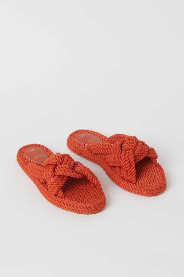 Disponible en naranja, beige o negro, esta sandalia con tiras trenzadas de tela es de H&M y tiene un precio de 19,99 euros.