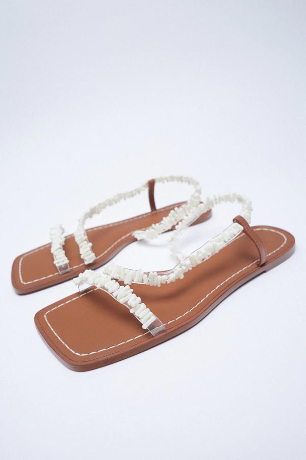 En color blanco y con tiras finas con detalle de abalorios en el corte, esta sandalia plana con punta cuadrada es de Zara y tiene un precio de 29,95 euros.