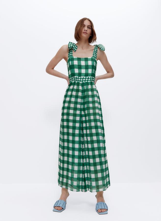Confeccionado en lino y con estampado de cuadros vichy en verde, este mono midi de tirantes con lazada y escote recto tiene un precio de 129 euros.