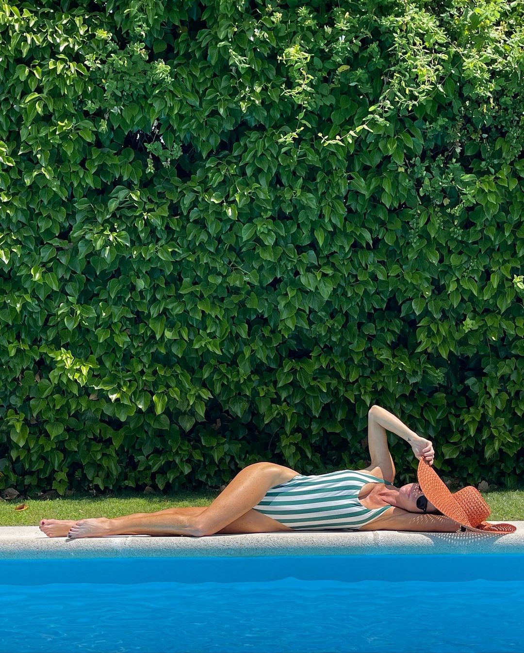 Amelia Bono con bañador de rayas de Oysho en la piscina de su casa en Madrid.