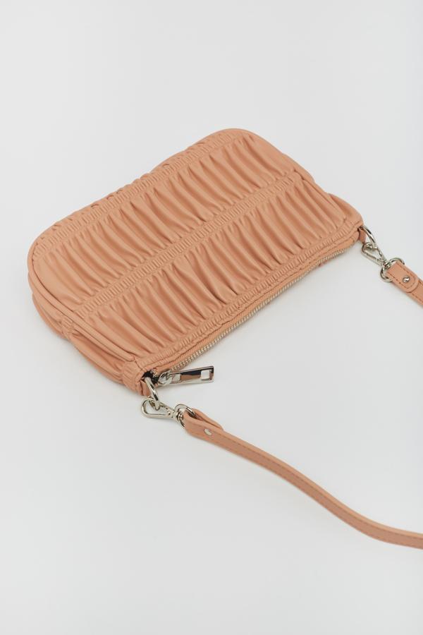 Disponible en rosa maquillaje y en azul, esta bandolera con detalles fruncidos y asa al hombro extraíble tiene cierre superior de cadena y de 16,99 euros ha pasado a costar 11,99 euros.