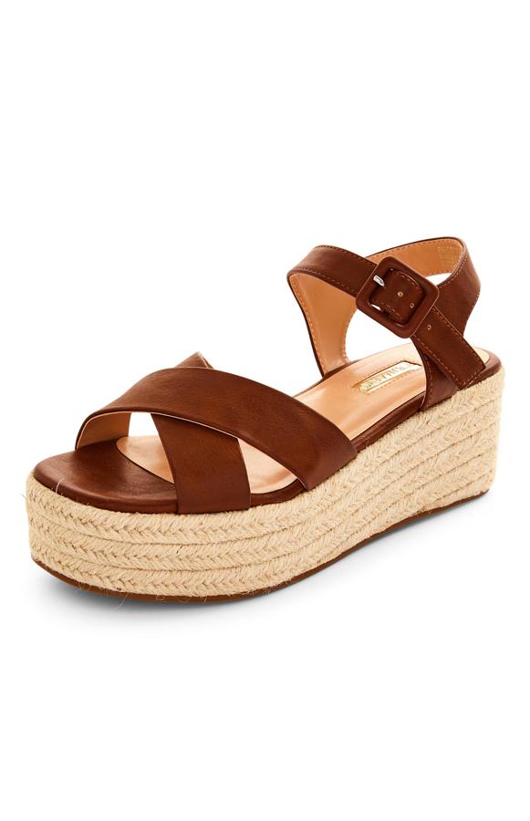 Con plataforma de yute, estas sandalias con tiras marrones y cierre con hebilla tienen un precio de 14 euros.