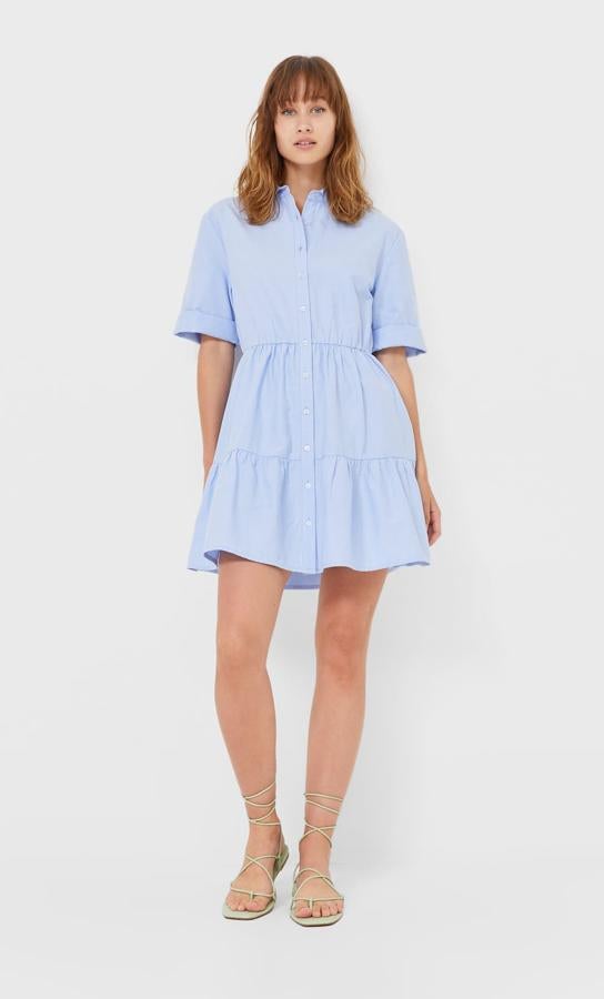 Disponible en azul celeste, blanco o rosa, este vestido camisero corto con cierre frontal con botones y bajo acabado en volantes tiene un precio de 17,99 euros.