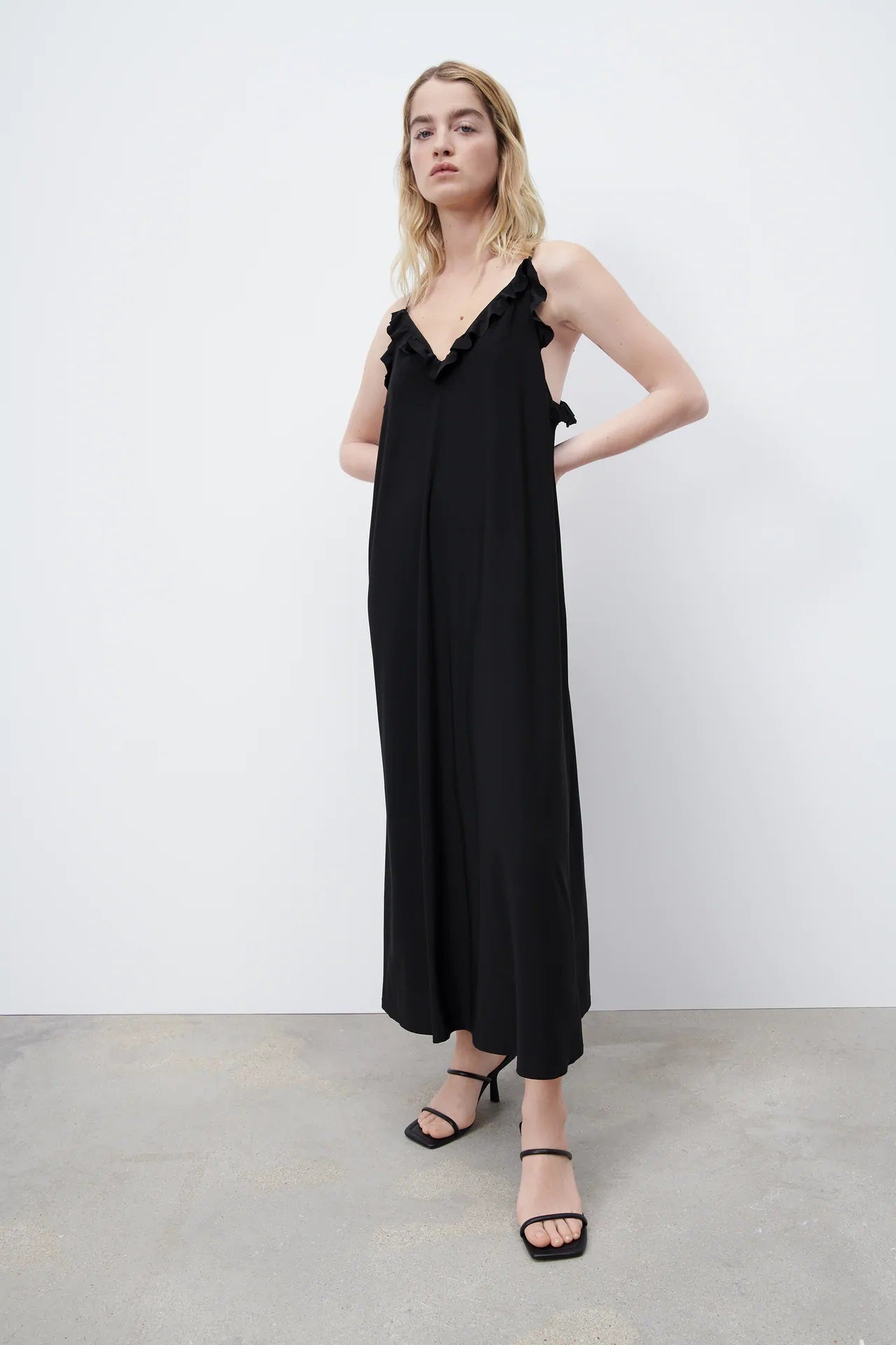 Escote a pico, corte midi y volantes. Este vestido negro de Zara pega con todo. (15,95 euros).
