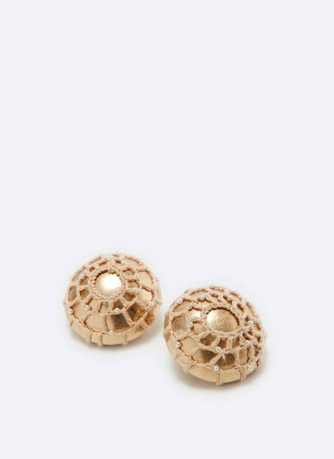 Estos pendientes de botón en color oro son una forma original de sumarte a una de las grandes tendencias del verano: el crochet. Tienen un precio de 29 €.