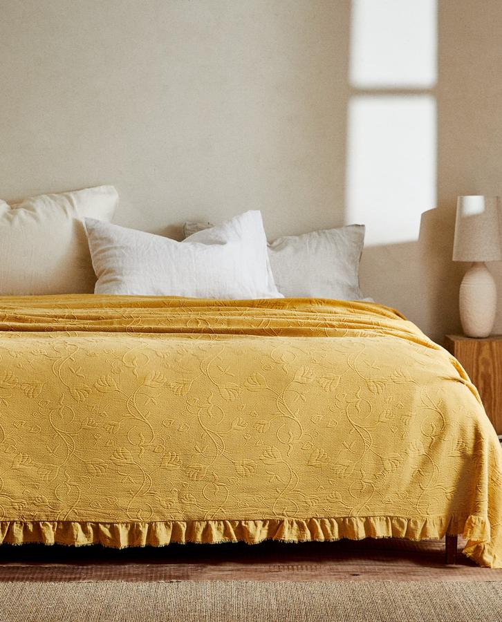 Confeccionada con algodón, esta colcha con relieve de flores y apliques de volante desflecado en los extremos está disponible en dos medidas, 230x250 centímetros y 270x280 centímetros, y tiene un precio de 49,99 y 79,99 euros respectivamente.