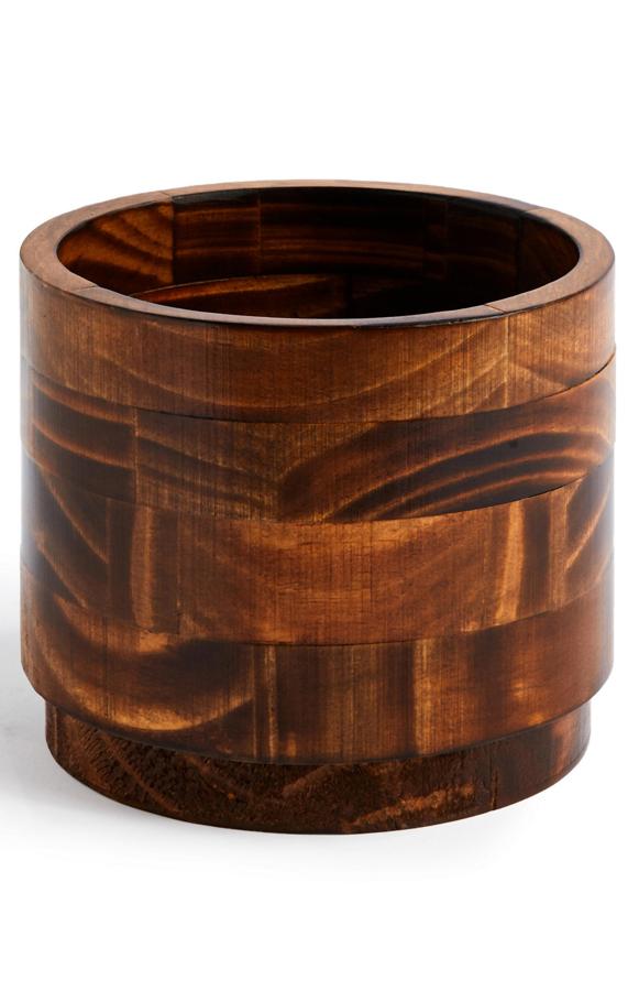 Este macetero redondo de madera tiene un precio de 7 euros.