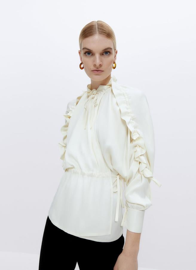 Con detalle de fruncidos en el cuello y la cintura y volantes en las mangas tres cuartos, esta camisa en color crudo de diseño recto y puños abotonados costaba 89 euros y ahora podemos encontrarla en la talla S por 59,95 euros. 