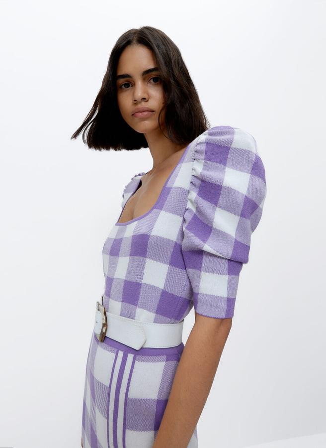 Este jersey de punto en jacquard con estampado vichy de cuadros en lila y blanco viene con escote cuadrado y mangas abullonadas y podemos encontrarlo en las tallas M y L por 39,95 euros (antes 69 euros).