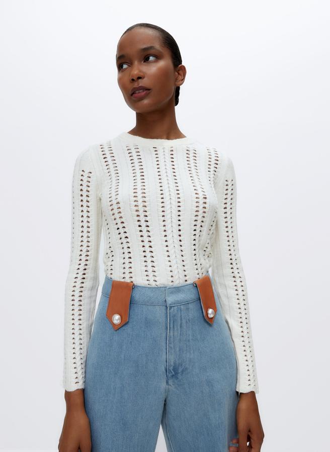 En color crudo y punto fantasía con trenzas y calados, este jersey de cuello redondo y mangas largas viene con acabados en rib y de 69 euros ha pasado a costar 35,95 euros. 