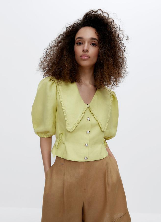 Confeccionado en lino de alta calidad en color lima, este top de escote de pico con cuello bobo desmontable y tapeta frontal con botones especiales viene con mangas abullonadas y detalle de lacitos en los laterales. De 79 euros ha pasado a costar 49,95 euros y solo queda en la talla XS.