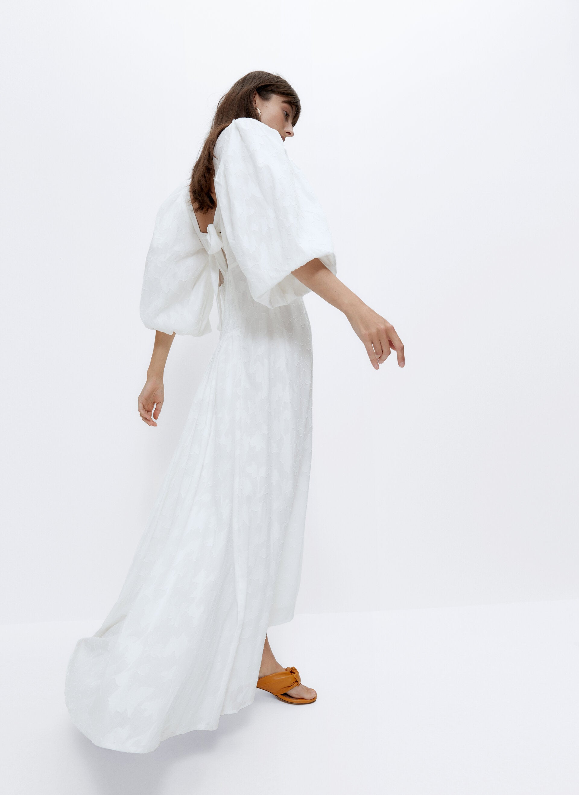 Vestidos blancos hay muchos, pero tan bonitos como este maxi con mangas farol y espalda al aire de la nueva colección de Uterqüe, ninguno... Cuesta 159 euros, y en las rebajas se ha quedado en 99.95 euros.