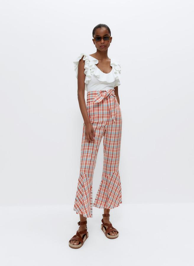 Los cuadros no pasan de moda y estos pantalones con volante en el bajo podrás llevarlos con zapatillas, sandalias y hasta botines en invierno. Rebajados de 89 a 59,95 euros).