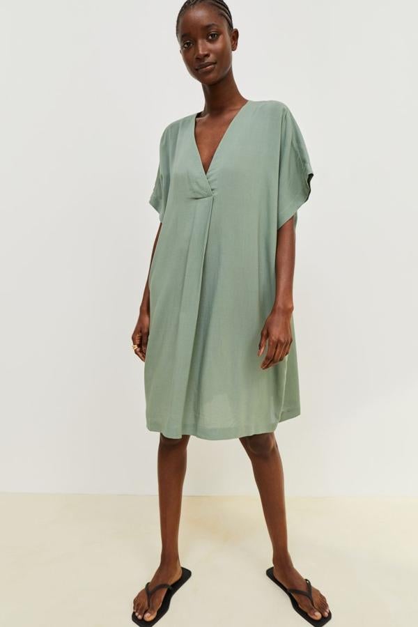 En verde salvia, con escote de pico, mangas cortas y pliegue delantero para efecto drapeado, este vestido de H&M hasta la rodilla sin forrar cuesta 19,99 euros y está disponible entre las tallas XS y XXL. 