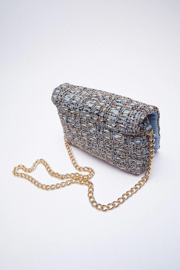 Disponible en azul o en beige, este bolso formato bandolera con detalle de abalorios cuenta con asa de hombro de cadena y tiene un precio de 29,95 euros.